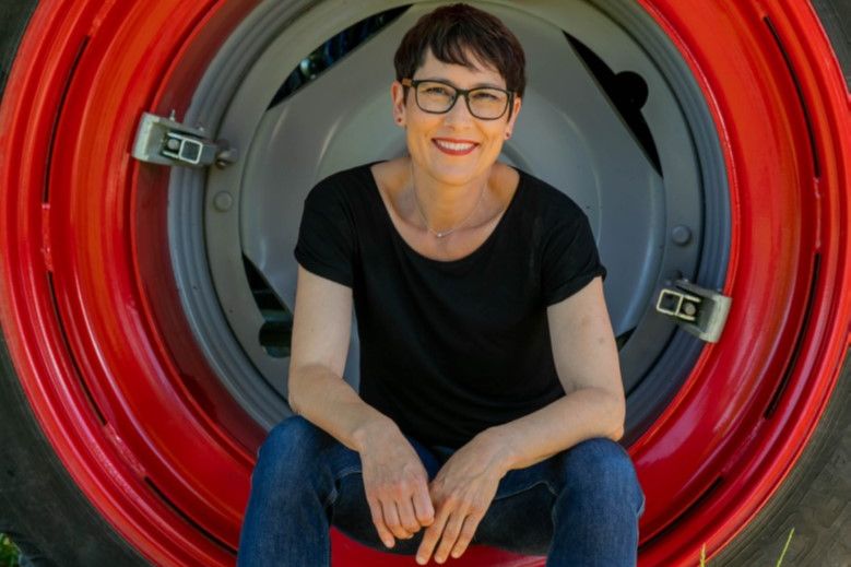 Colette Basler sitzt in einem Rad eines Traktors