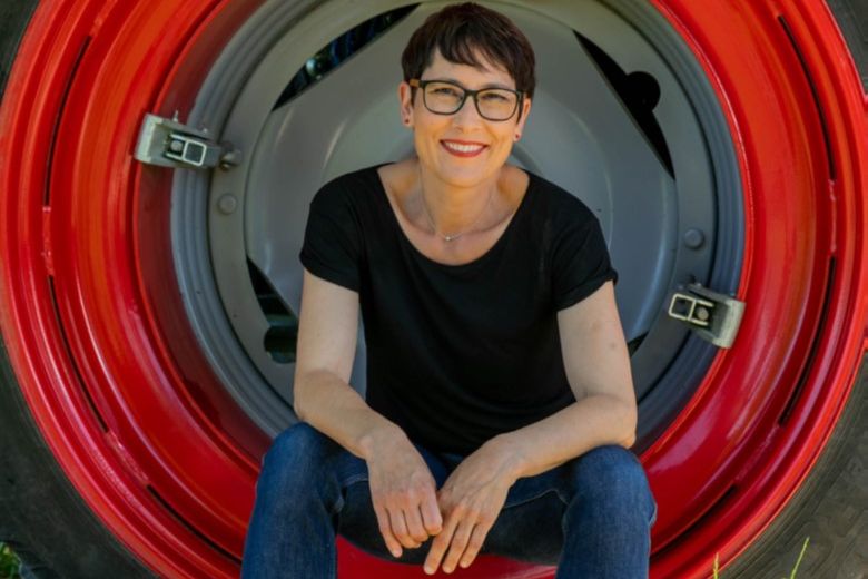 Colette Basler sitzt in einem Rad eines Traktors