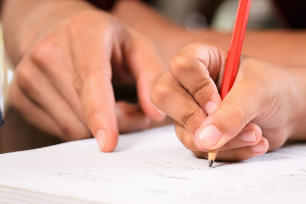 Ein Mädchen schreibt als Hausaufgabe einen Aufsatz.