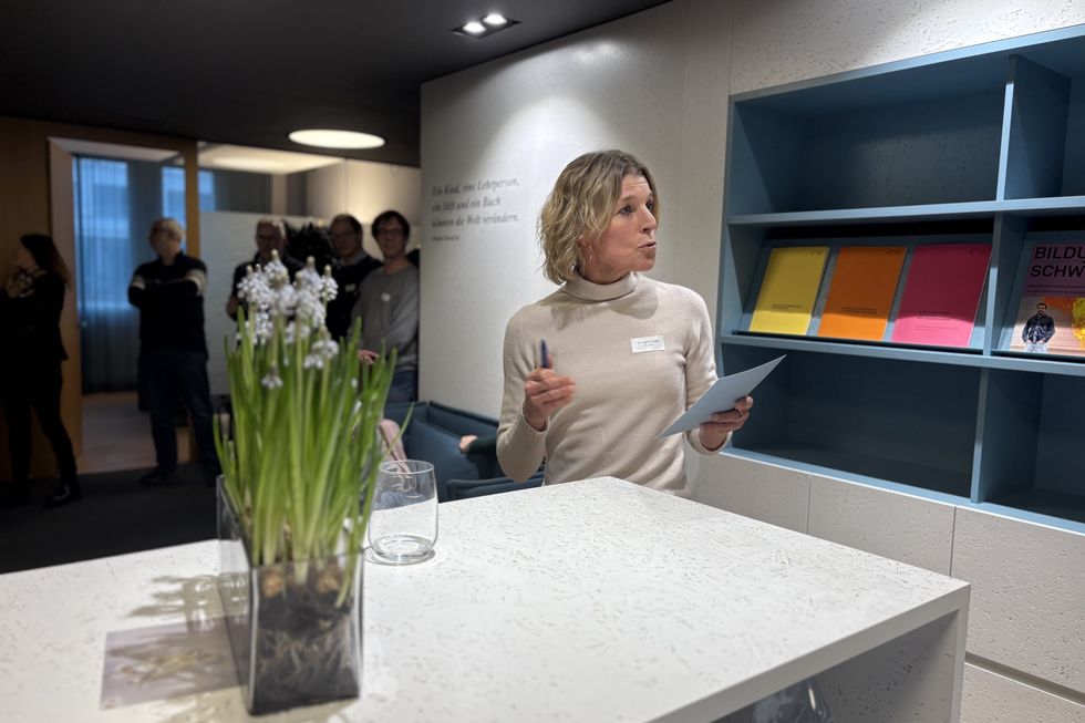 Eine Frau spricht vor einem Tresen.