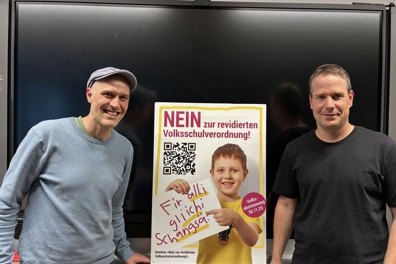 Zwei Männer vor einem Plakat.