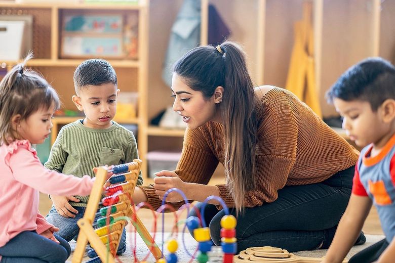 Eine Betreuerin spielt mit Kindern. 