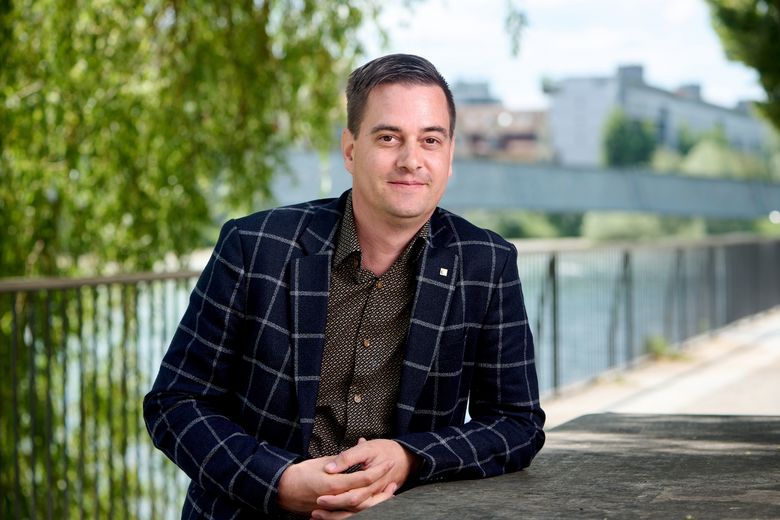 Mann mit Sakko sitzt an der Limmat.