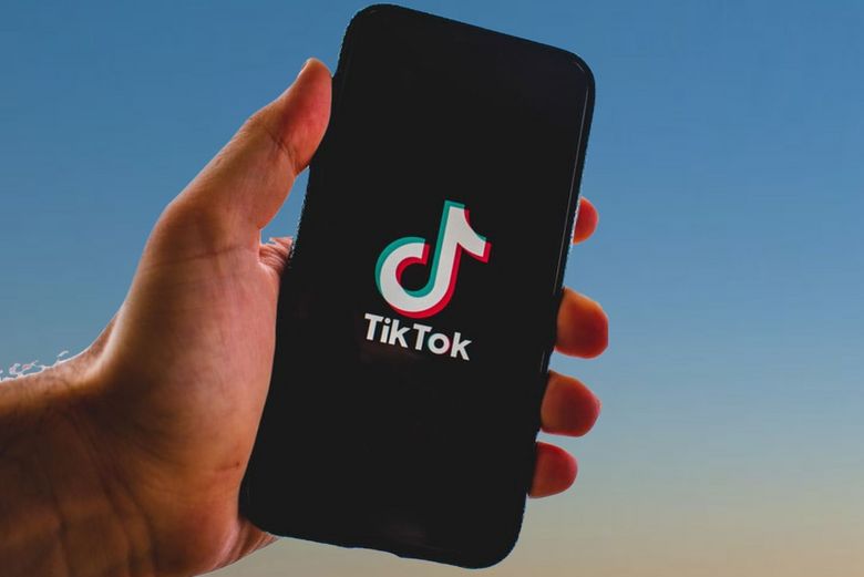 Eine Hand hält ein Smartphone. Auf dem Gerät ist das Tiktoklogo abgebildet.
