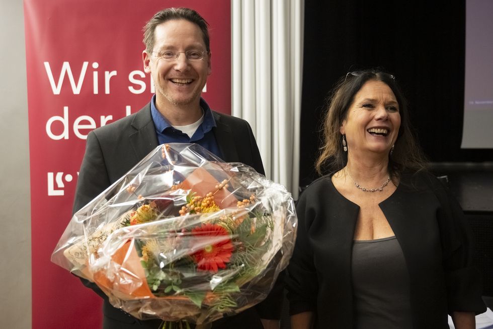 Michael Ochsenbein hält einen Blumenstrauss. Neben ihm steht Cristina Mattiello.