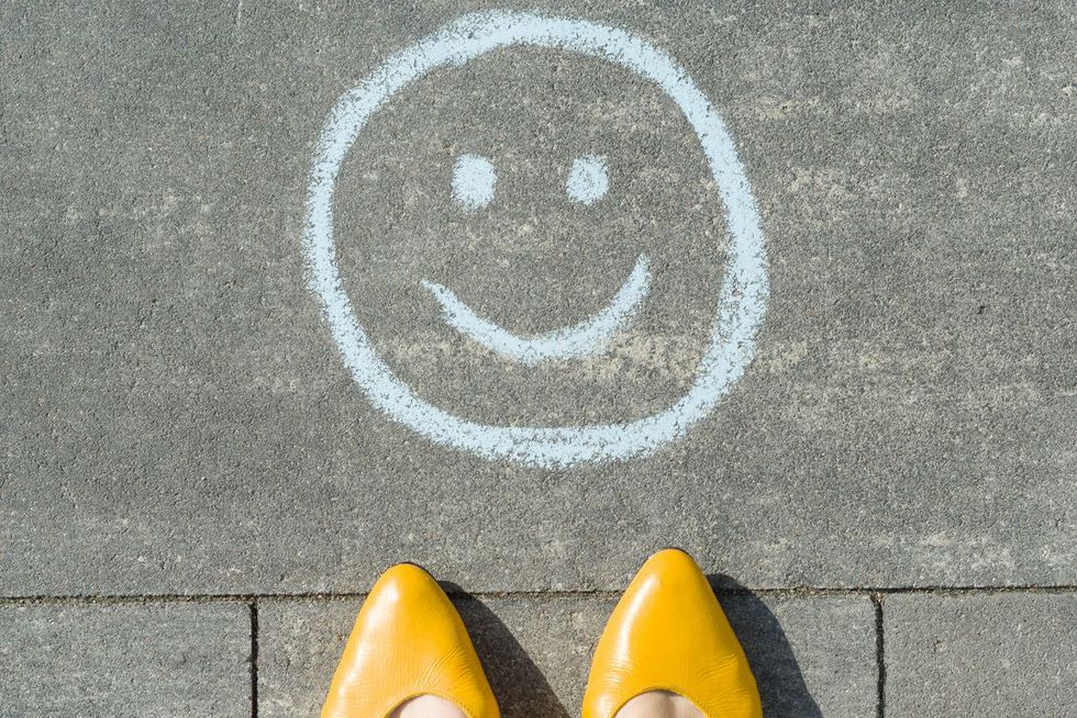 Ein Smiley wurde mit Kreide auf dem Asphalt gezeichnet.