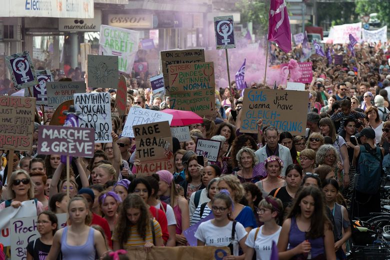 Viele Frauen gehen gemeinsam auf einer Strasse. Sie halten zum Teil Schilder und Banner hoch, auf denen Botschaften für die Anliegen des feministischen Streiks zu lesen sind.