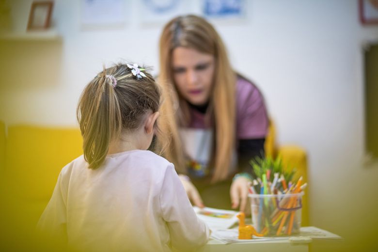 Lehrerin leitet Schulkind beim Erledigen einer Aufgabe an