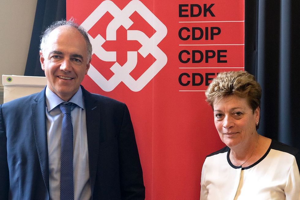 Christophe Darbellay und Silvia Steiner vor einem Banner der EDK.