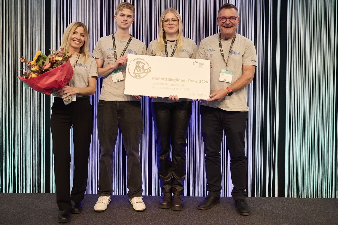 Zwei Frauen und zwei Männer stehen lächend auf einer Bühne
