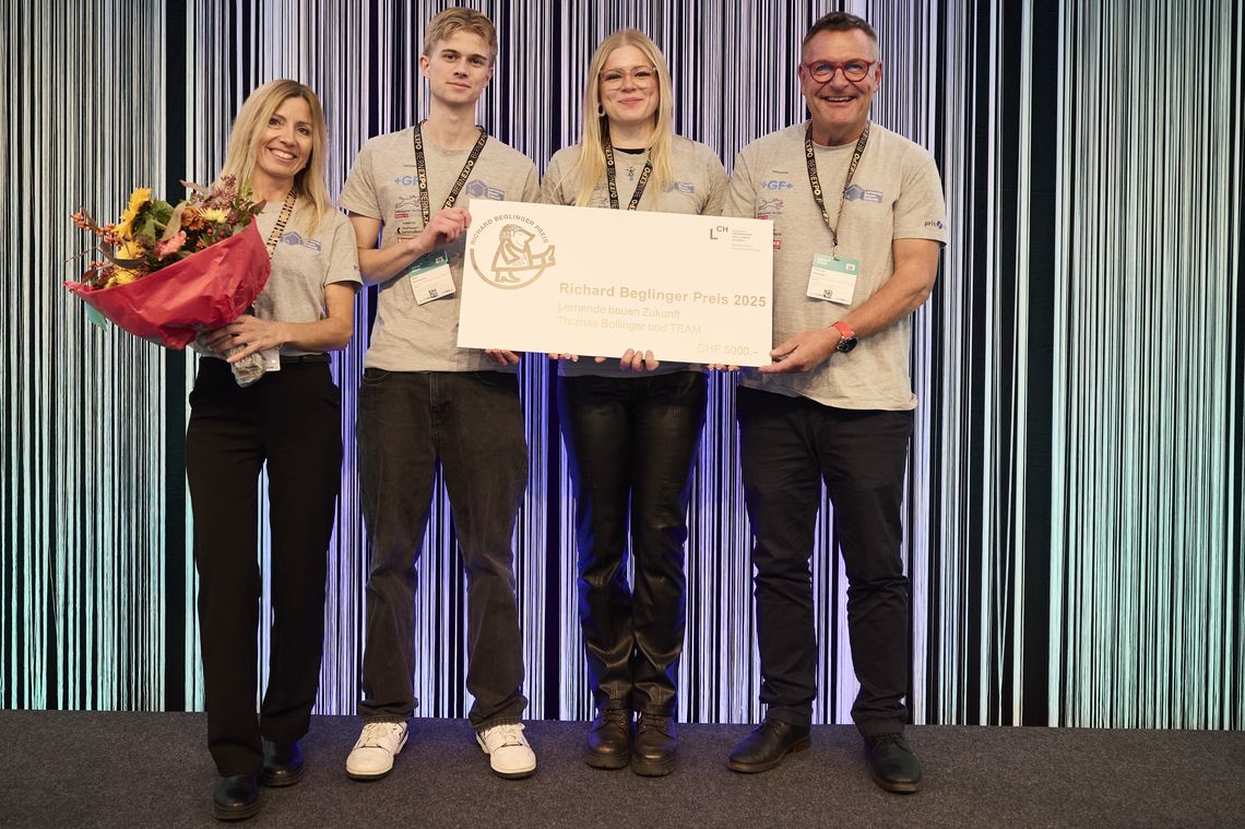 Zwei Frauen und zwei Männer stehen lächend auf einer Bühne