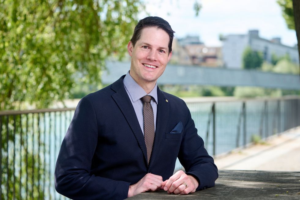 Mann sitzt an einem Fluss.