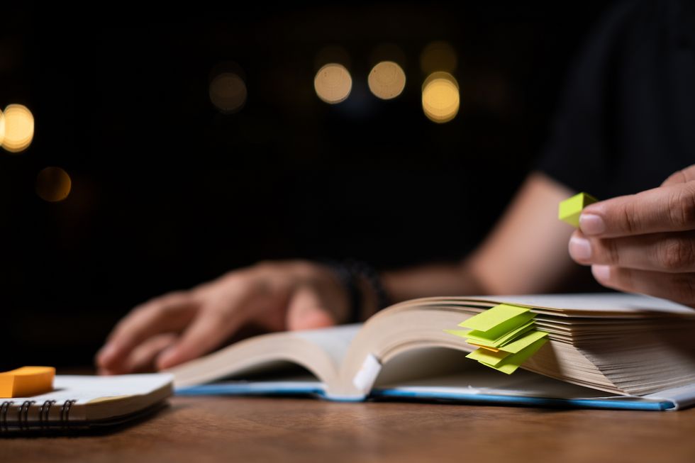 Auf einem Tisch liegt vor einer Person ein Buch.