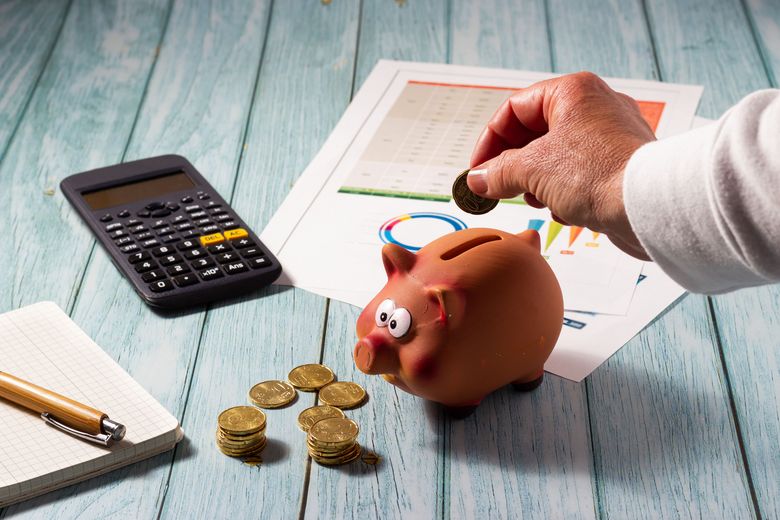 Frau wirft Geld in ein Sparschwein.