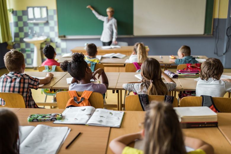 Lehrerin schreibt an Wandtafel.